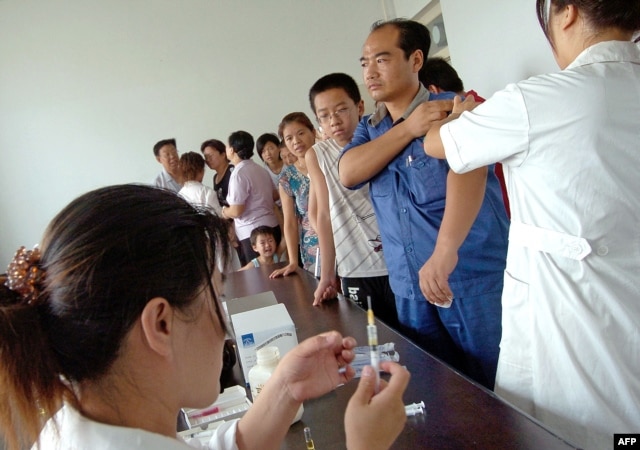 FILE - Residents queue up for their vaccine shots at a local hospital in Yuncheng, in northern China's Shanxi province.