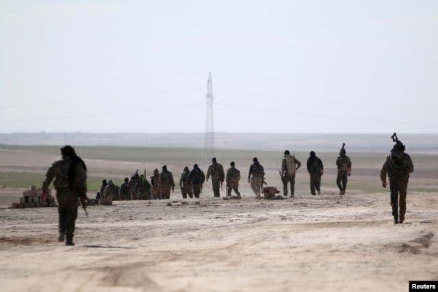 FILE - Syria Democratic Forces walk in an area they have taken control of from Islamic State fighters in Hasaka countryside, Syria, Feb. 19, 2016. U.S. Secretary of State John Kerry called the cease-fire the best way to try to end the five-year war in Syria.