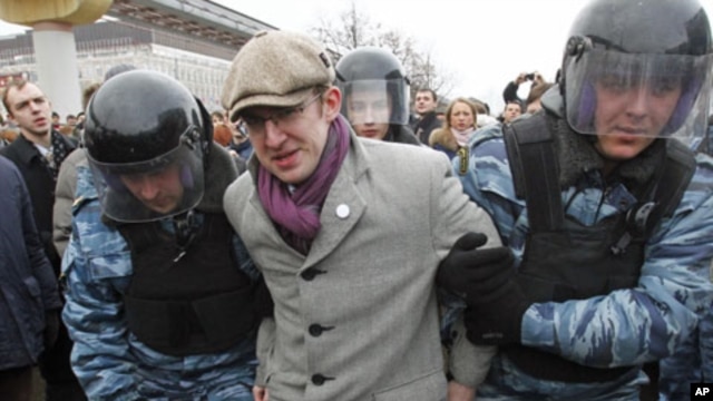 Riot police detain a protester during a rally near the state-controlled TV channel NTV tower in Moscow, March 18, 2012.