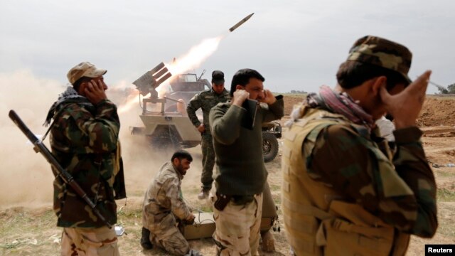 Члены шиитского ополчения ведут огонь по позициям боевиков «Исламского государства» у города аль-Алам недалеко от Тикрита. 9 марта 2015 г.