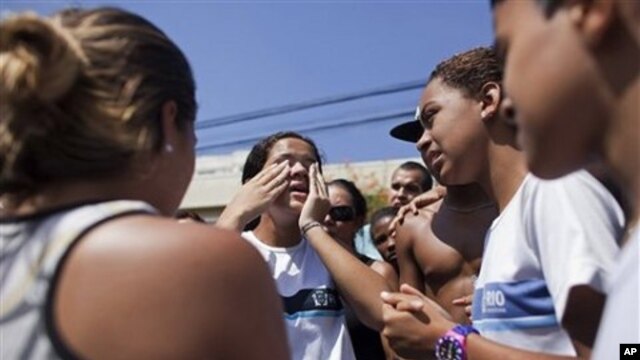 A student tells her schoolmates that she saw dead bodies inside their school after a shooting in Rio de Janeiro, Brazil, April 7, 2011