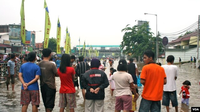 Residents of Kampung Melayu look at the flood waters on a bridge, South Jakarta, Indonesia, January 17, 2013. (K. Lamb/VOA)