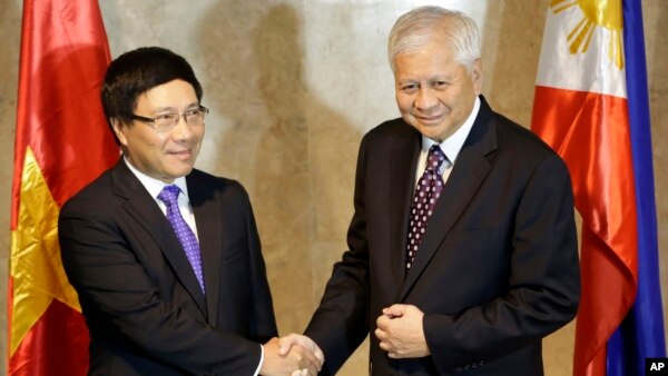 Philippine Foreign Affairs Secretary Albert Del Rosario, right, welcomes Vietnamese Foreign Minister Pham Binh Minh for their 7th Meeting of the Philippines-Vietnam Joint Commission for Bilateral Cooperation (JCBC) in Manila, Philippines, Aug. 1, 2013 .