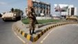 An army soldier stands guard on a road leading to a polling station during a re-polling for the general elections in Karachi, May 19, 2013. 