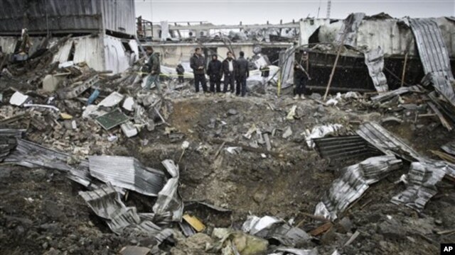 Afghan security members of Contrack company stand at the scene of a car bomb explosion in Kabul, Afghanistan,  December 17, 2012. 
