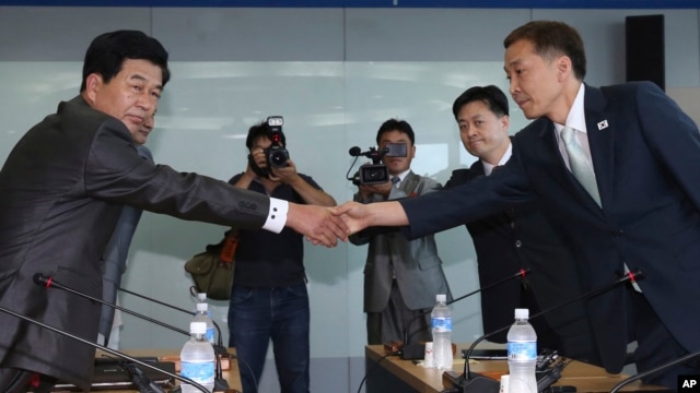 韩国首席谈判代表金桂冠和朝鲜首席谈判代表朴哲洙握手