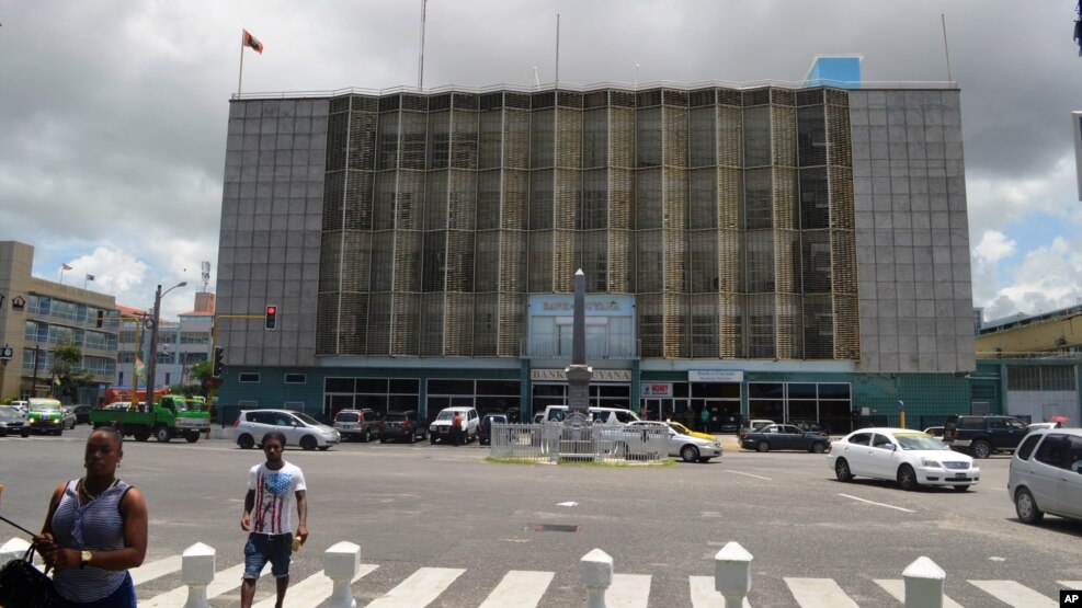 People walk near the central bank in Georgetown, Guyana, where the discovery of major oil and gas deposits offshore in the Atlantic have ignited hope that one of the poorest countries in the Western Hemisphere will undergo an economic transformation.