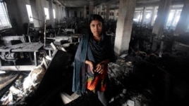 Bangladeshi garment worker Laiju stands inside the damaged Smart Export Garment Ltd. factory where a fire Saturday claimed the lives of seven of her female colleagues in Dhaka, Bangladesh, Sunday, Jan. 27, 2013.