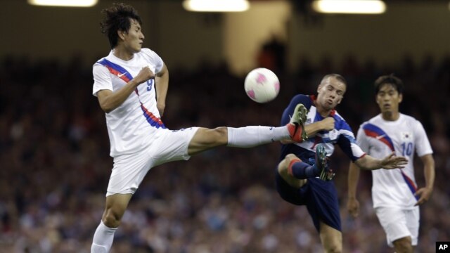 Ji Dong-won de Corea del Sur y el británico Tom Cleverley, disputan la pelota durante el juego que Corea del Sur ganó a los locales en la ronda de penaltis.
