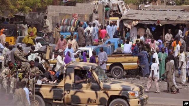 File - Nigerian soldiers ride on the back of an armed truck as they patrol at a local market Tuesday, Jan. 27, 2015, after recent violence in surrounding areas at Maiduguri, Nigeria. Islamic extremists are rampaging through villages in northeast Nigeria’s