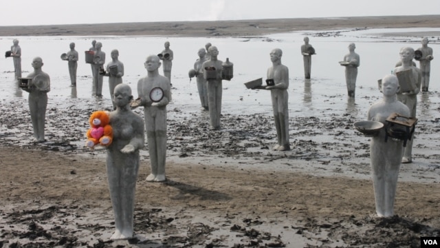 Patung-patung manusia lumpur di area tanggul kolam penampungan lumpur Lapindo, Rabu (28/5), menandai peringatan delapan tahun tragedi semburan lumpur panas. (VOA/Petrus Riski)