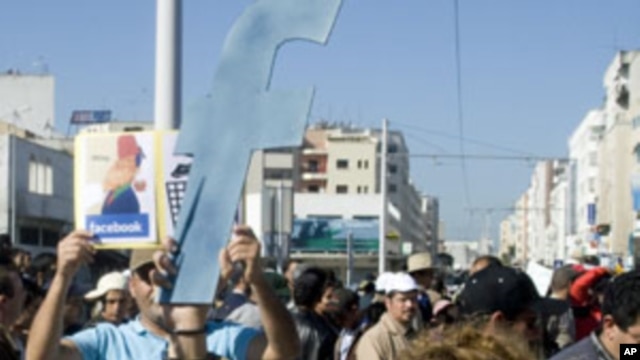A protester holds up a cut-out of the letter "F" in an apparent recognition of the social network site Facebook's role in the recent revolts in Arab countries, Rabat, Morocco, March 20, 2011