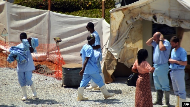 Health workers walk in an isolation center for people infected with Ebola at Donka Hospital in Conakry, April 14, 2014. 