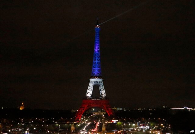 The Eiffel Tower is illuminated in the French national colors red, white and blue in honor of the victims of the terror attacks last Friday in Paris, Monday, Nov. 16, 2015.