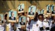 Procession participants shield themselves from the sun with portraits of the late former Cambodian King Norodom Sihanouk in a funeral procession in Phnom Penh, February 1, 2013.
