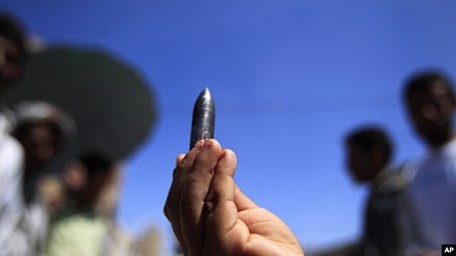 A bullet fired by security forces during clashes with tribal fighters loyal to the opposition is displayed during a rally to demand the ouster of Yemen's President Ali Abdullah Saleh in the southern city of Taiz, October 28, 2011.