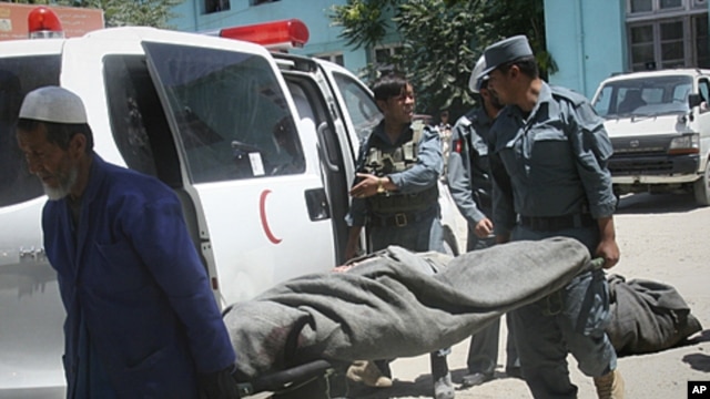 The lifeless body of a police officer is carried from an ambulance at the hospital in Ghazni, west of Kabul, Afghanistan, June 22, 2011.