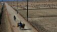 FILE - North Korean farmers pass along a road past farm fields at a collective farm near the town of Sariwon, North Korea.