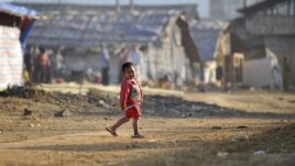 A refugee child from Burma's Bhamo city walks inside a rescue camp in the Chinese southwestern border city of Longchuan, Yunnan province February 10, 2012. In an obscure part of southwest China, a refugee crisis from one of the world's longest running and