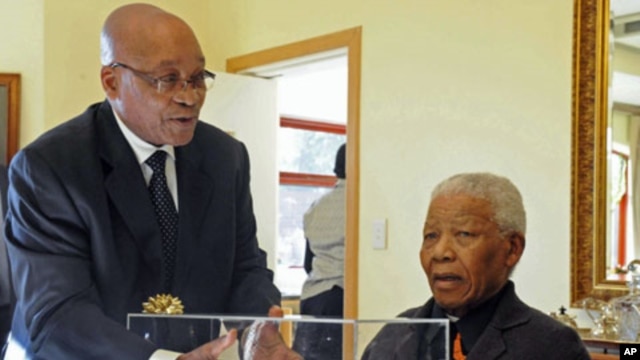 South African President Jacob Zuma presents former President Nelson Mandela with a gift - an architect's rendering of the Nelson Mandela Legacy Bridge - (file photo)