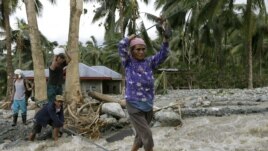 Residents cross a river using suspended ropes at Andap, New Bataan township, Compostela Valley in southern Philippines, Dec. 5, 2012, a day after Typhoon Bopha made landfall.