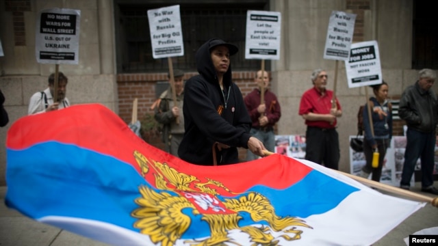 一名抗議者在烏克蘭駐紐約領館前揮舞俄羅斯總統旗。（2014年5月8日）