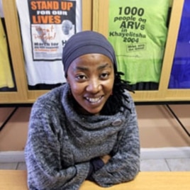 AIDS activist Vuyiseka Dubula sits beneath t-shirts in the offices of the Treatment Action Campaign in Cape Town's Khayelitsha township May 31, 2011