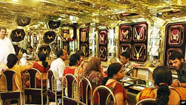 Customers look at gold jewelry at a shop on the occasion of a Hindu festival 'Akshay Tritiya' in Allahabad, India, 16 May 2010
