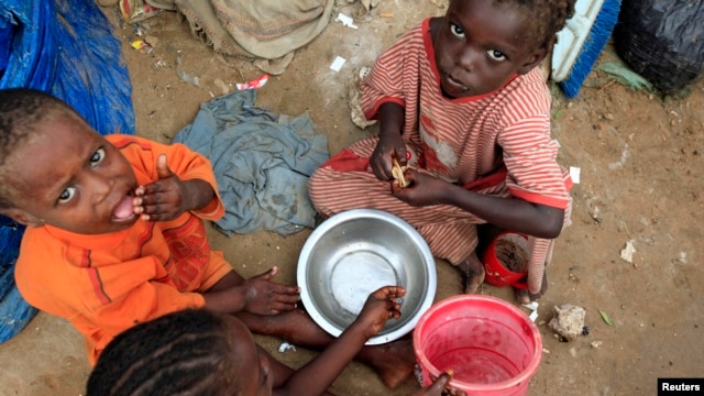 Internally displaced Somali children eat breakfast at Sayyidka camp in the Howlwadag district, south of Somalia's capital Mogadishu, May 3, 2013. 