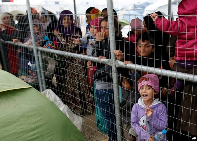 Migrants wait for food in the makeshift refugee camp at the northern border point of Idomeni, Greece, March 23, 2016.