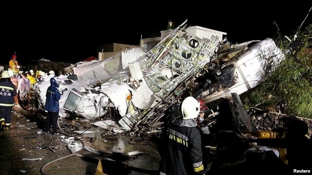 Pata petugas penyelamat mengamati bangkai pesawat TransAsia Airways penerbangan GE222 yang jatuh di Pulau Penghu, Taiwan (23/7). (Reuters/Wong Yao-wen)