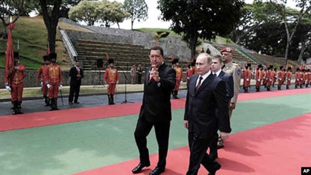 Venezuelan President Hugo Chavez (L) and Russian Prime Minister Vladimir Putin receive military honors at the Presidential palace Miraflores in Caracas, 02 Apr 2010