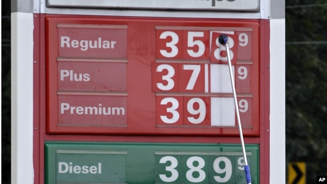 A man changes fuel prices at a ConocoPhillips gas station in Little Rock, Ark. The price of oil fell to its lowest point in nearly two months. U.S. consumer confidence slow, encouraging, Sept. 26, 2012