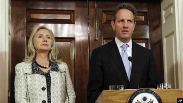 Secretary of State Hillary Rodham Clinton, left, listens to Treasury Secretary Tim Geithner, speak about new sanctions the U.S. is taking to increase pressure on Iran, at the State Department in Washington, Monday, Nov. 21, 2011.