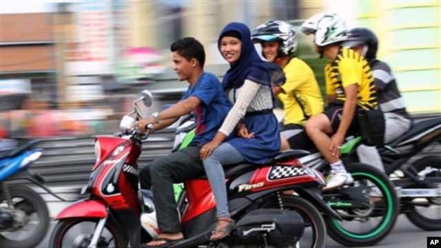 Perempuan Aceh membonceng sepeda motor di Lhokseumawe (7/1). (AP/Rahmat Yahya)