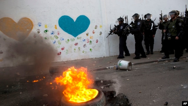Polisi anti huru-hara Israel dalam bentrokan dengan warga Palestina di kota Ar'ara Israel Arab utara, Sabtu 5 Juli 2014.