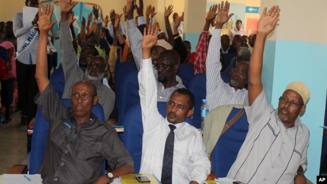 Somali MPs raise their hands during session to impeach Prime Minister Abdi Farah Shirdon, in Mogadishu, Somalia, Dec. 2, 2013.