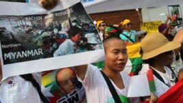 A minority Kachin holds up an image showing Kachin refugees in northern Burma during a protest in front of Burmese Embassy in Bangkok, Thailand, January 11, 2013. 