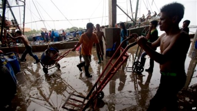 Các công nhân di trú làm việc tại một chợ cá trong tỉnh Samut Sakhon, nằm về hướng tây thủ đô Bankok, 20/6/14