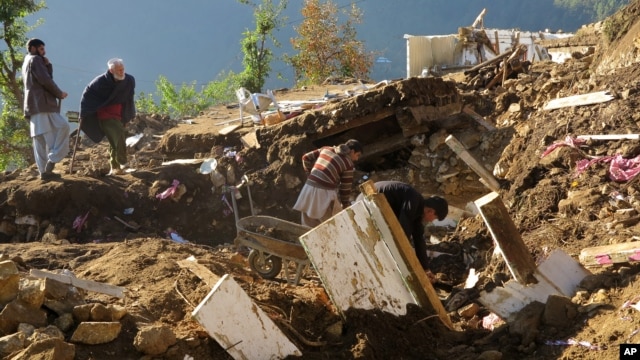 Pakistani villagers collect their belongings under the rubble of their homes destroyed from an earthquake in Shangla in Swat valley, Pakistan, Oct. 28, 2015.  