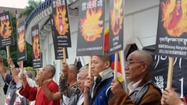 Tibetans display portraits of people who killed themselves in protest of Chinese policies in Tibet, Liberty Square, Taipei, October 19, 2011.
