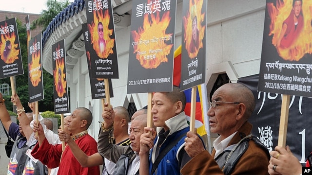 Tibetans display portraits of people who killed themselves in protest of Chinese policies in Tibet, Liberty Square, Taipei, October 19, 2011.