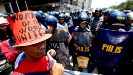 Riot police block protesters as they try to march towards U.S. Embassy in Manila to mark International Labor Day, May 1, 2013 in Manila, Philippines.