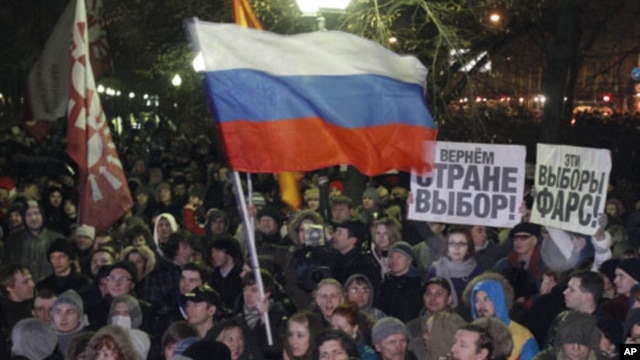 People wave the Russian flag and hold posters reading "This election is farce!" and "Give the country choice back" during an opposition rally in Moscow, Russia, December 5, 2011.