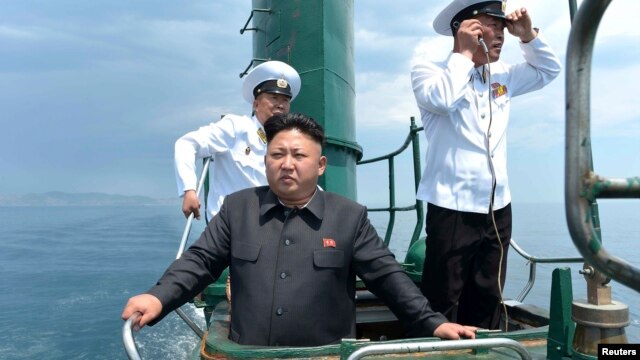 Chủ tịch Bắc Hàn Kim Jong Un đứng trên một chiếc tàu ngầm trong khi thị sát một đơn vị hải quân hôm 14/6/2014.