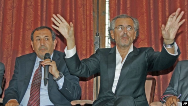 French philosopher Bernard-Henri Levy (R) and Suleiman Fortia, Misrata TNC member, speak during a news conference after lobbying French President Sarkozy for weapons supplies, in Paris, July 20, 2011
