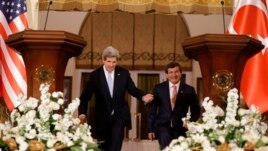 U.S. Secretary of State John Kerry, left, enters a news conference with Turkish Foreign Minister Ahmet Davutoglu in Ankara, Turkey, on March 1, 2013. 