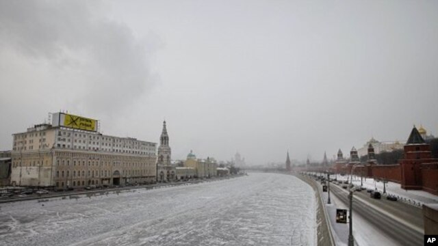 A giant anti-Prime Minister and presidential candidate Vladimir Putin billboard set up by the opposition Solidarity movement on a building, left, which faces the Kremlin, right, is seen in downtown Moscow on February 1, 2012.
