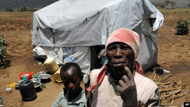 A resident of Vumilia Eldoret Camp with family. Many residents have lived for three years in tents intended to last for six months.