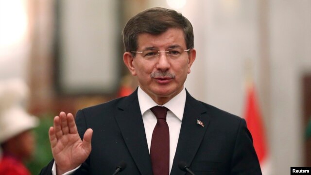 FILE - Turkey's Prime Minister Ahmet Davutoglu speaks to reporters in Baghdad, Nov. 20, 2014.